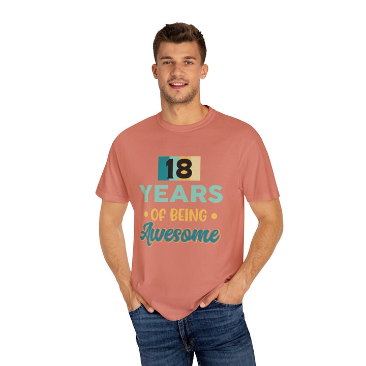 Sea Dragon Dreams unisex 18th birthday t-shirt in garment-dyed coral cotton worn by a smiling man with blue jeans.