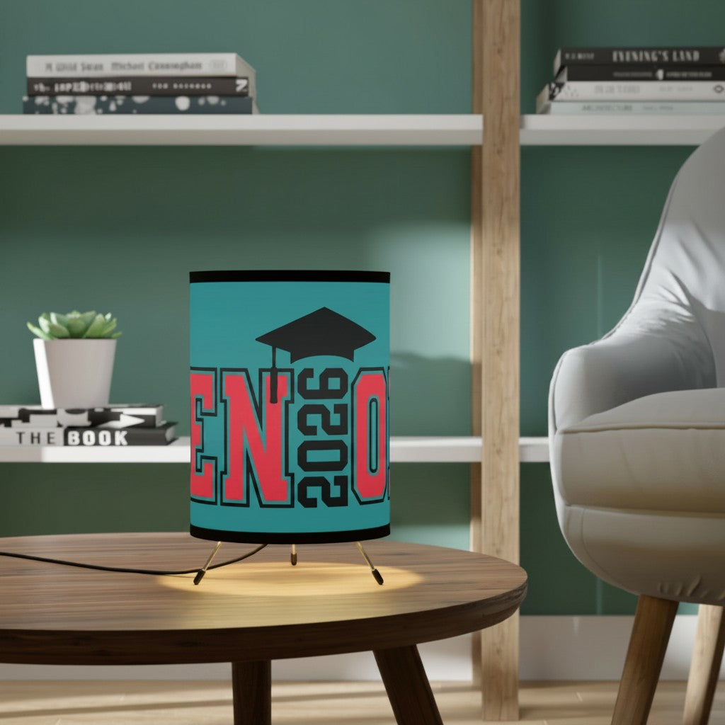 Sea Dragon Dreams 2026 graduation tripod lamp with a teal shade, black mortarboard icon, and red text on a wood table.