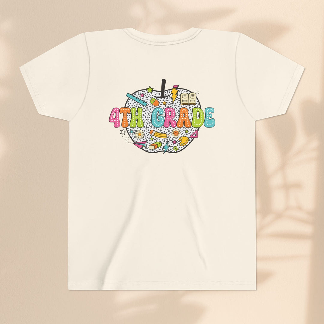 Sea Dragon Dreams 4th Grade youth t-shirt in cream cotton with a colorful apple graphic featuring school supplies.