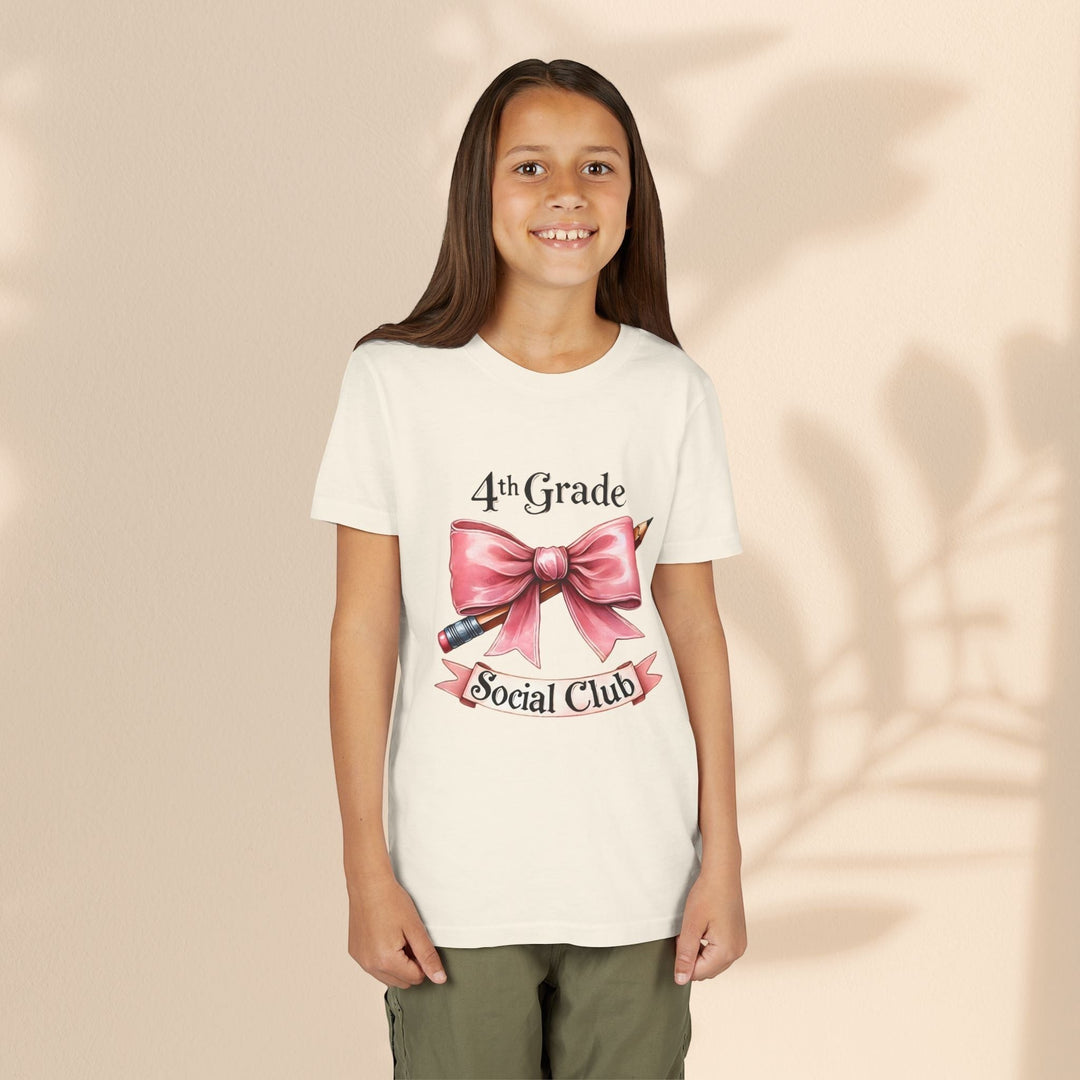 Sea Dragon Dreams youth tee featuring a 4th Grade Social Club graphic with a pink bow and pencil on cream cotton.