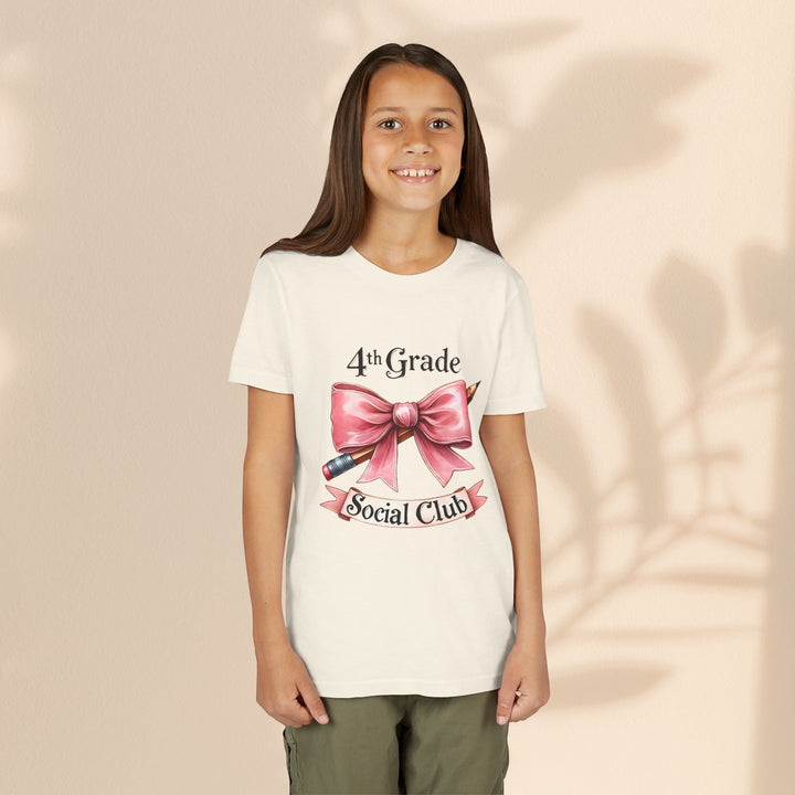 Sea Dragon Dreams youth tee featuring a 4th Grade Social Club graphic with a pink bow and pencil on cream cotton.
