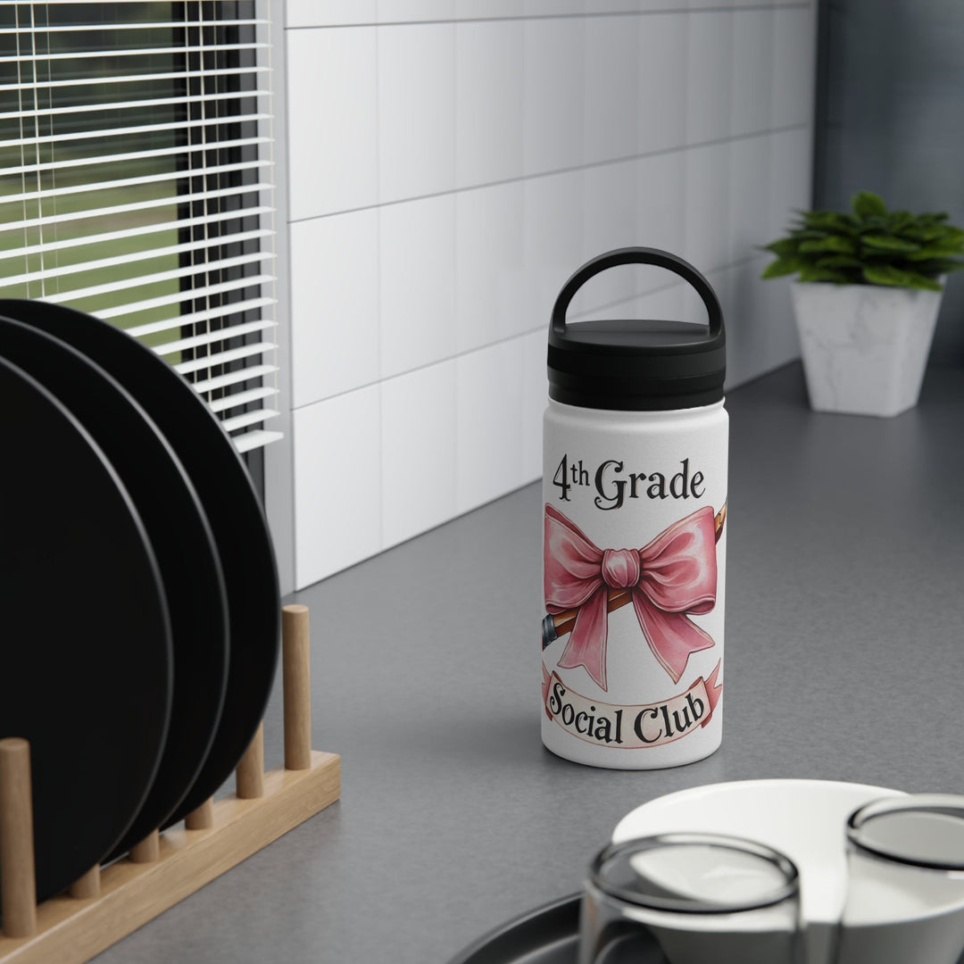 Sea Dragon Dreams 4th Grade Social Club insulated water bottle with a pink bow design on a kitchen counter.