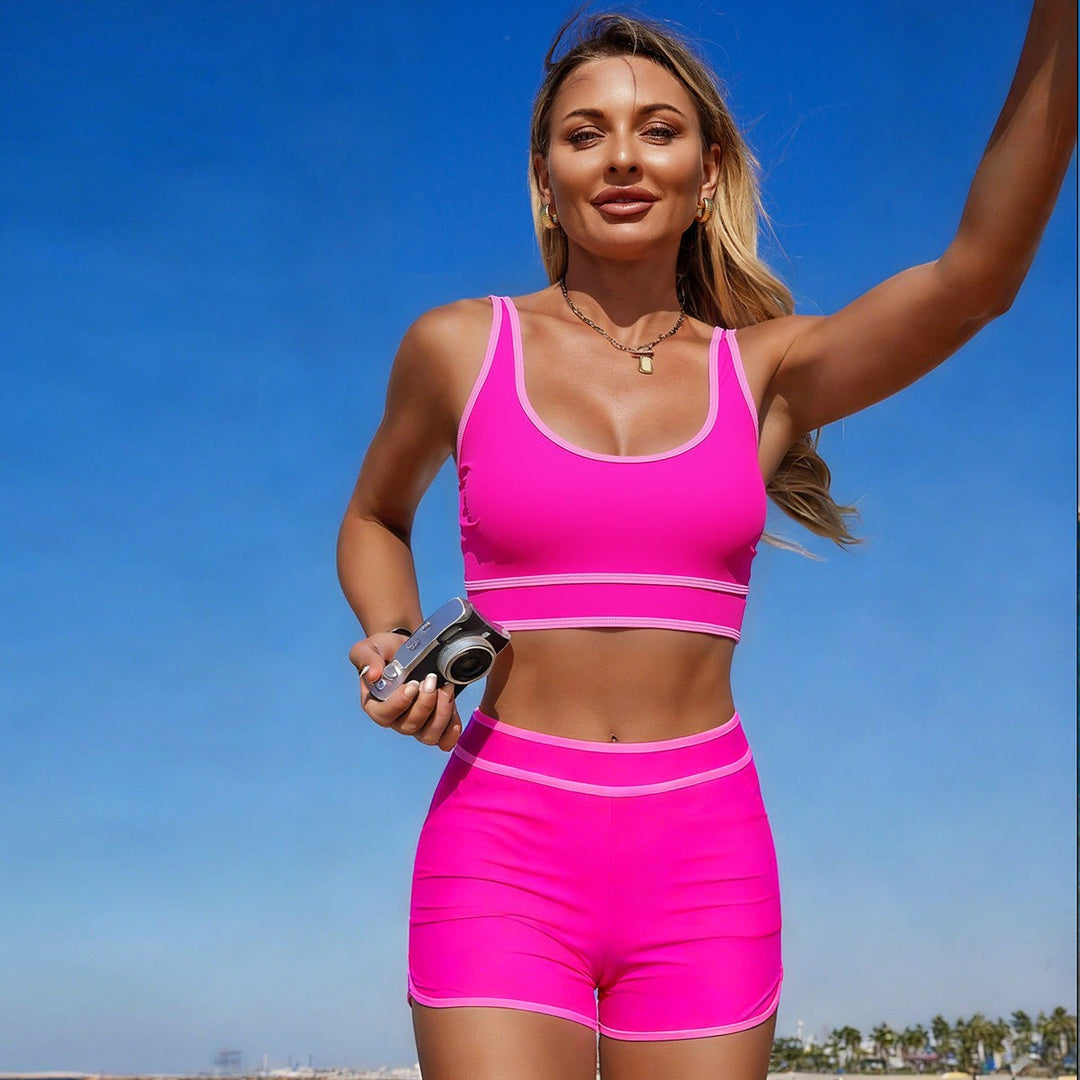 Sea Dragon Dreams athletic hot pink bikini set with sporty scoop neck top and matching shorts on a sunny beach