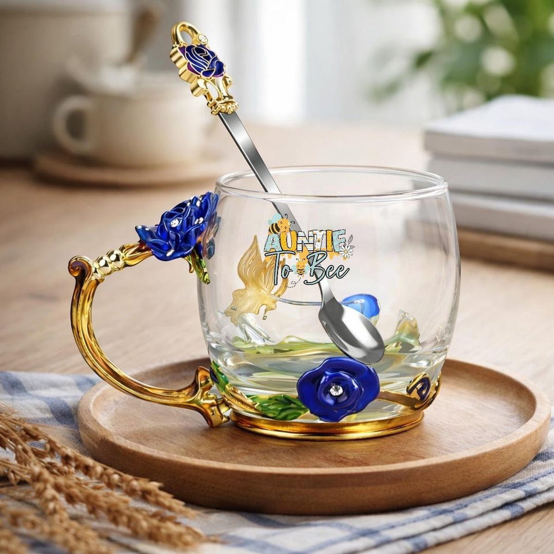 Sea Dragon Dreams Aunt to Be glass mug with enamel floral details, gold handle, and matching decorative spoon.