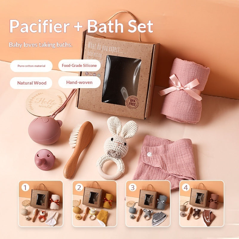Sea Dragon Dreams baby care gift set featuring a pink cotton drool towel, wooden brush, pacifier, and bunny rattle.