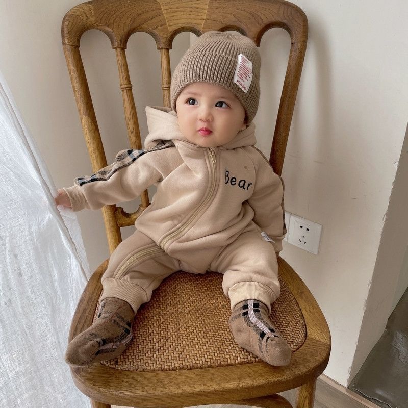 Sea Dragon Dreams baby wearing a coffee brown fleece-lined cotton onesie with bear design and plaid accents