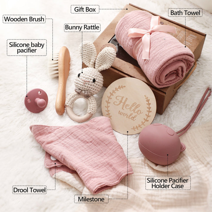 Sea Dragon Dreams baby gift set with pink muslin towel, wooden brush, bunny rattle, pacifier, and milestone disc.