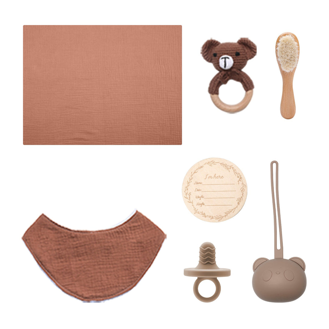Sea Dragon Dreams baby gift set featuring a muslin drool bib, bear rattle, wooden brush, pacifier, and milestone disc.