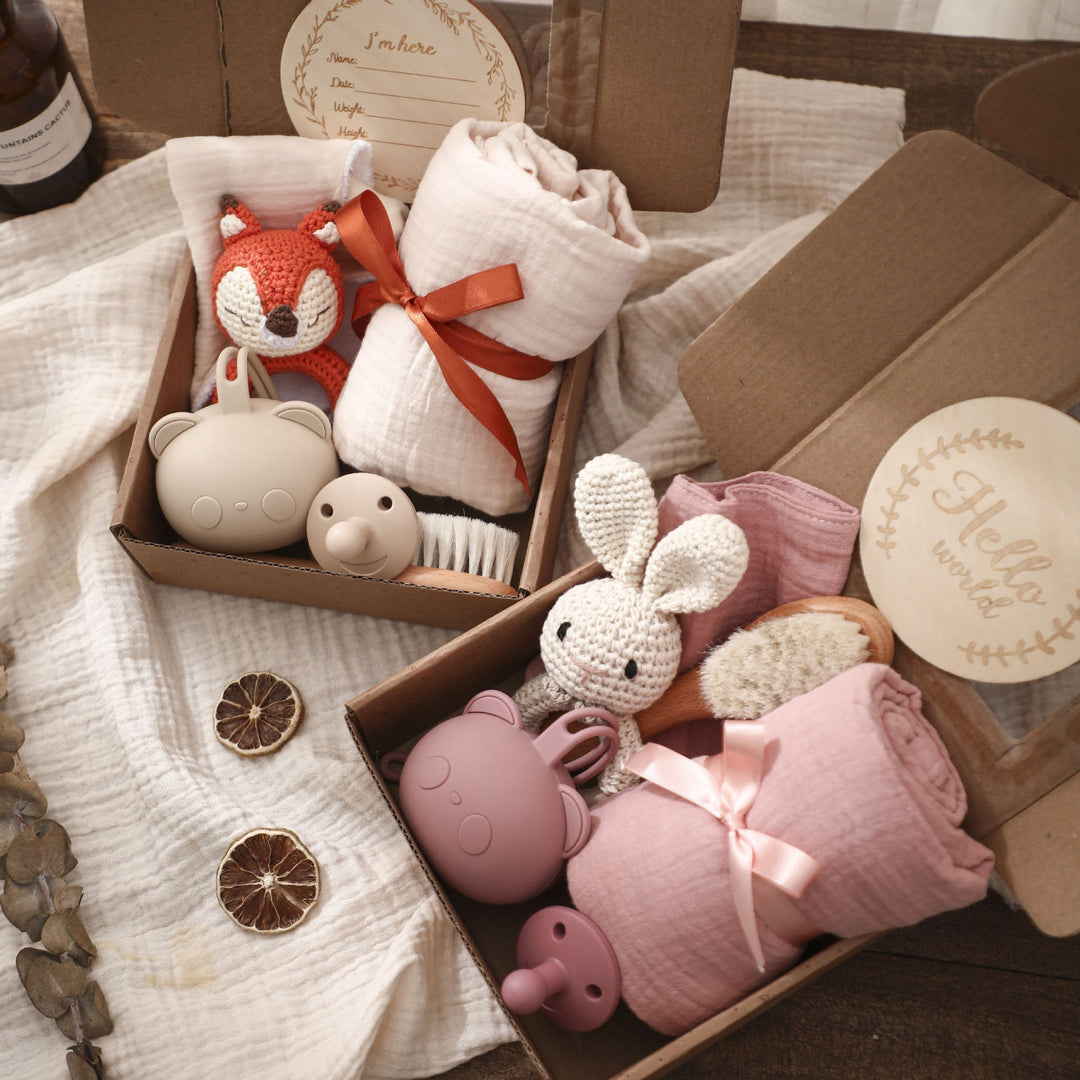 Sea Dragon Dreams baby gift sets featuring crochet animal toys, muslin swaddles, brushes, and pacifiers in boxes.