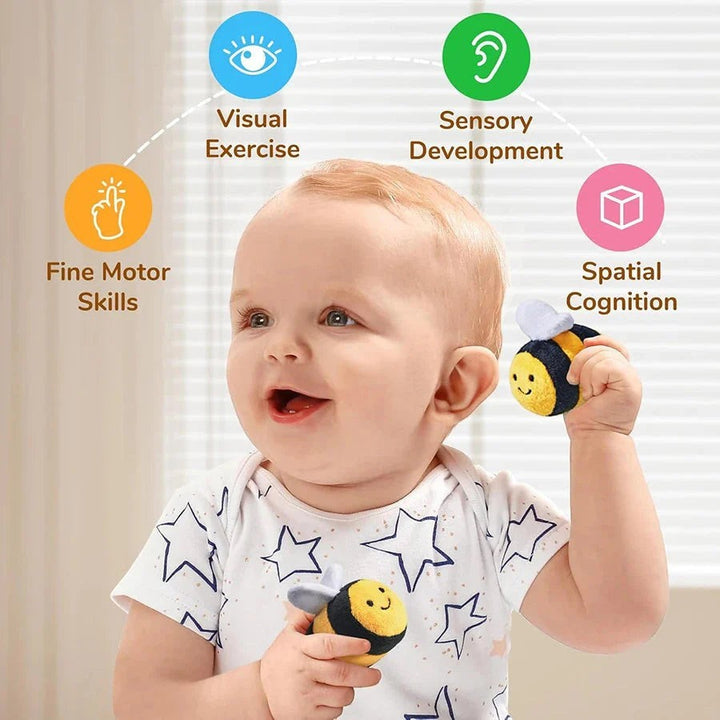Sea Dragon Dreams baby playing with soft plush bee rattles to develop fine motor skills and sensory awareness
