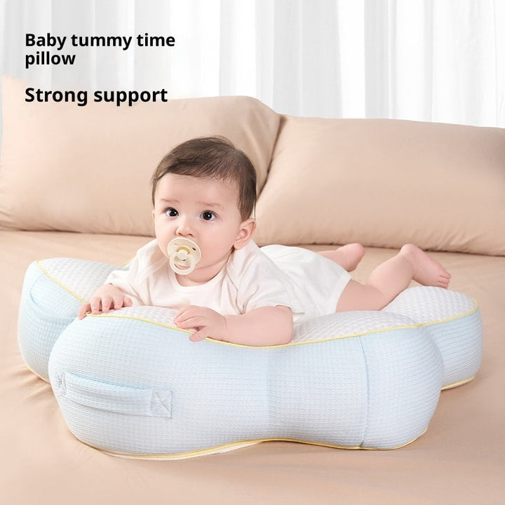 Sea Dragon Dreams baby nursing pillow in light blue providing support for an infant during tummy time on a bed