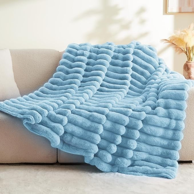 Sea Dragon Dreams BEDELITE light blue faux rabbit fur throw blanket with a 3D striped texture draped over a sofa.
