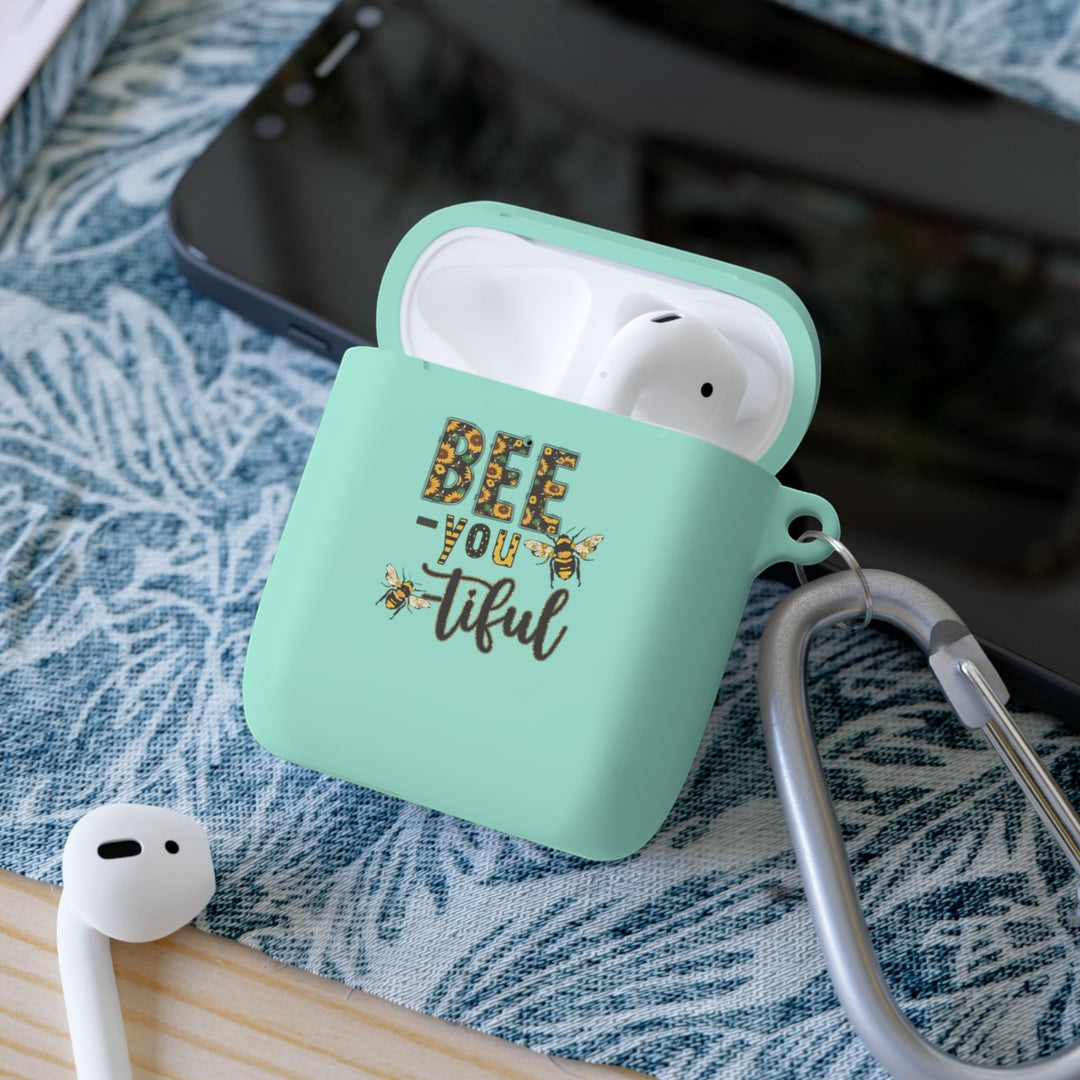 Sea Dragon Dreams Bee-You-Tiful floral AirPods case in mint green TPU with a metal carabiner on a patterned surface.