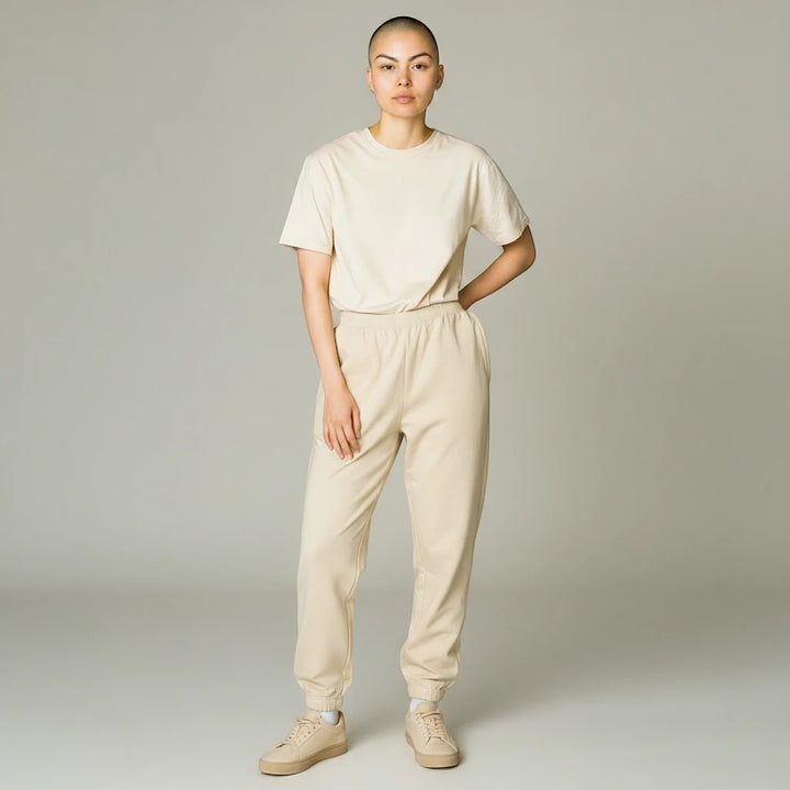 Sea Dragon Dreams model wearing a beige t-shirt and matching jogger pants with sneakers in a studio setting
