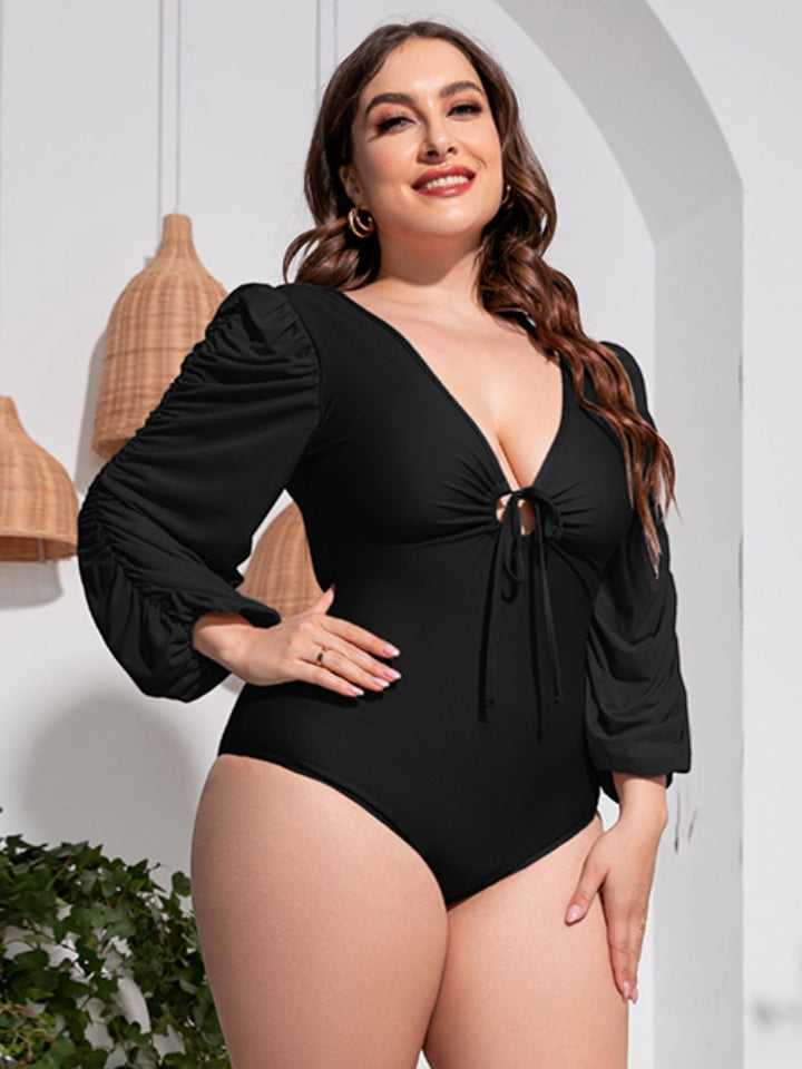 Sea Dragon Dreams plus size black one-piece swimsuit with deep V-neck, tie front, and ruched balloon sleeves