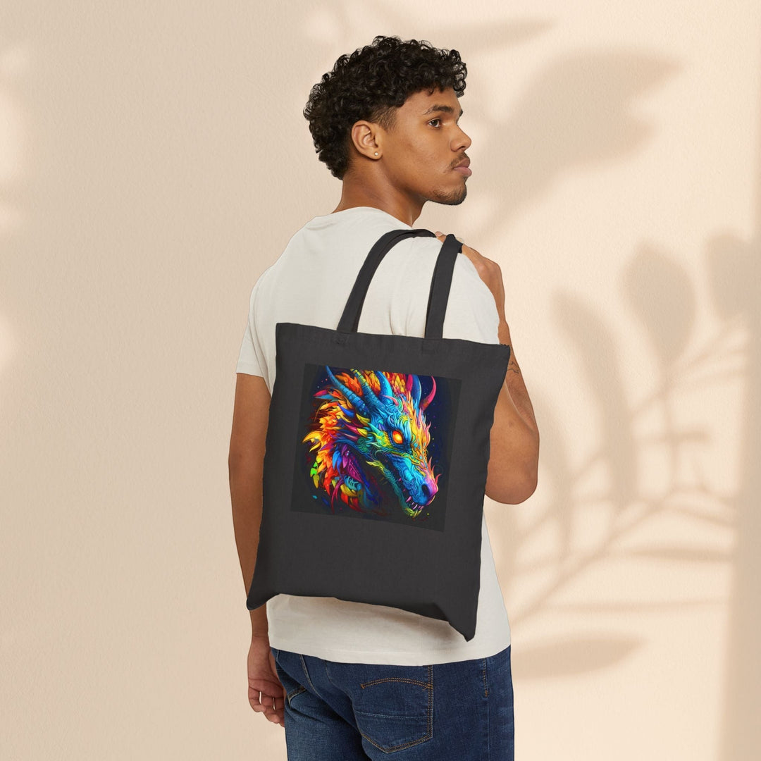 Man wearing a black Sea Dragon Dreams cotton canvas tote bag with a vibrant neon dragon graphic over his shoulder.