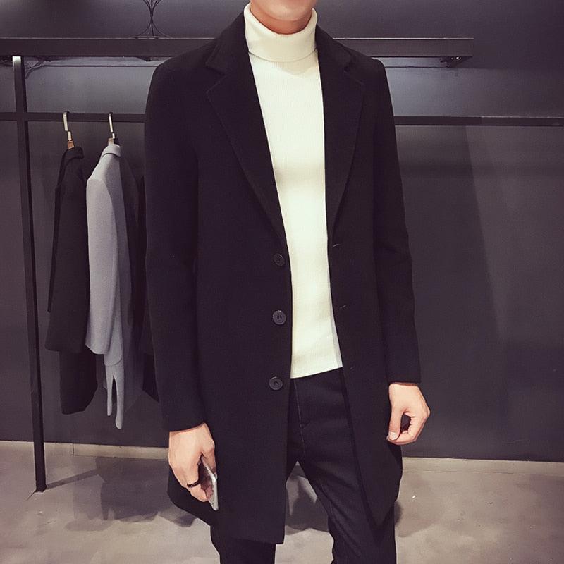 Sea Dragon Dreams men's black cotton trench coat with a turn-down collar worn over a white turtleneck sweater