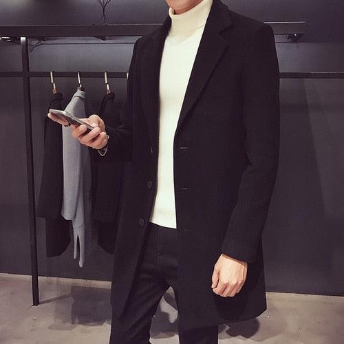 Sea Dragon Dreams men's black cotton trench coat with a turn-down collar worn over a white turtleneck sweater