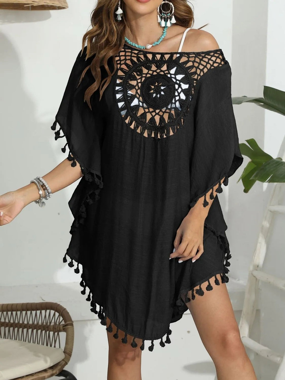 Sea Dragon Dreams black crochet beach cover-up with round neck, intricate openwork, and playful tassel hem details.