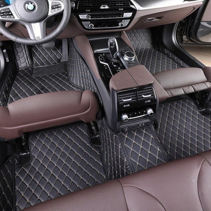 Sea Dragon Dreams black TPE car floor mats with beige diamond stitching installed in a luxury vehicle interior