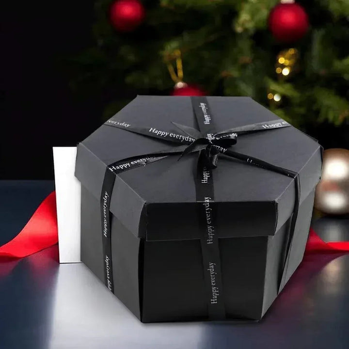 Sea Dragon Dreams black hexagonal explosion gift box tied with a ribbon, set against a festive holiday background.