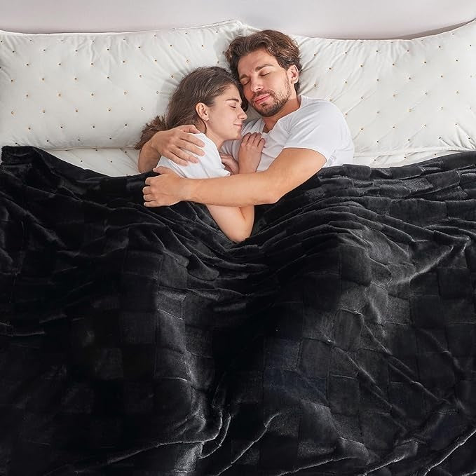 Sea Dragon Dreams black faux rabbit fur queen blanket with a checkered pattern draped over a couple in bed