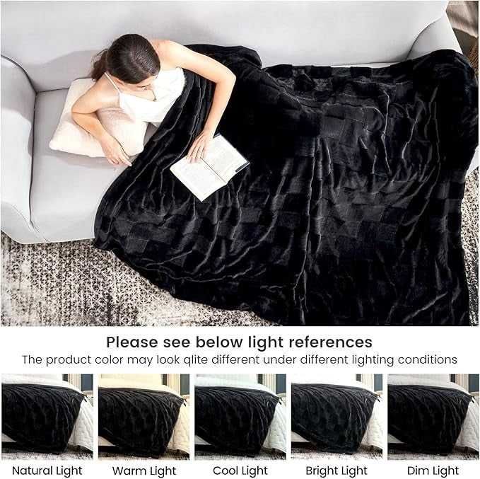 Sea Dragon Dreams black faux rabbit fur queen blanket with a checkered pattern, draped over a woman reading on a sofa.