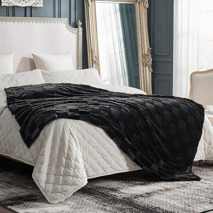 Sea Dragon Dreams black faux rabbit fur queen blanket with a dimensional checkered pattern draped on a white bed.
