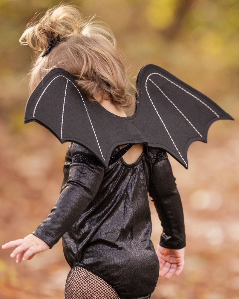 Sea Dragon Dreams black felt bat wings costume worn by a child with white stitching detail and elastic straps