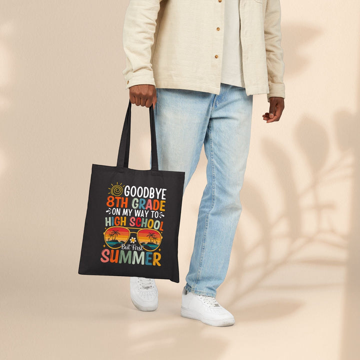 Sea Dragon Dreams black cotton canvas graduation tote bag with 8th grade summer graphic held by a person in jeans.