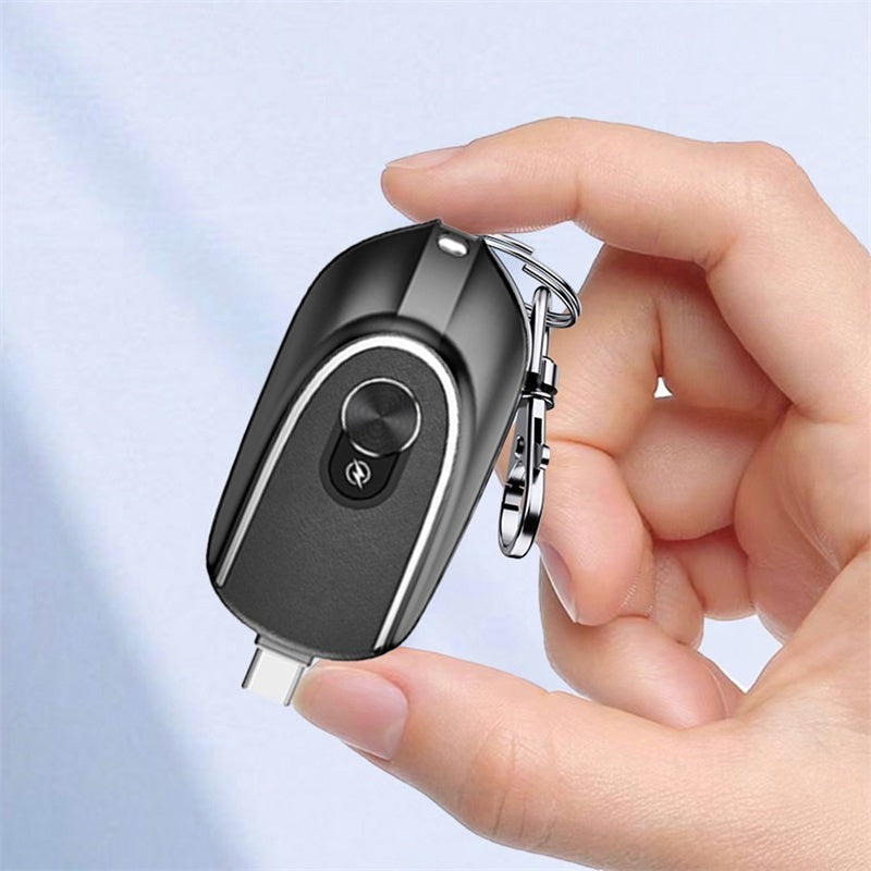 Sea Dragon Dreams black 2-in-1 mini keychain power bank with retractable USB-C connector held in a hand.
