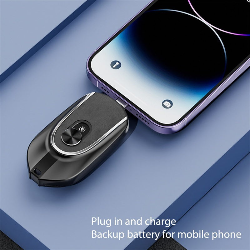 Sea Dragon Dreams black 1200mAh mini keychain power bank plugged into a smartphone for emergency charging.