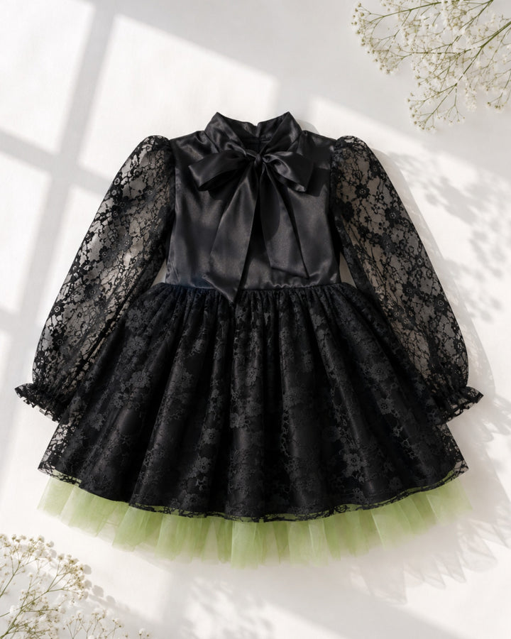 Sea Dragon Dreams girls' black satin witch dress with lace sleeves, bow neckline, and green tulle hem.