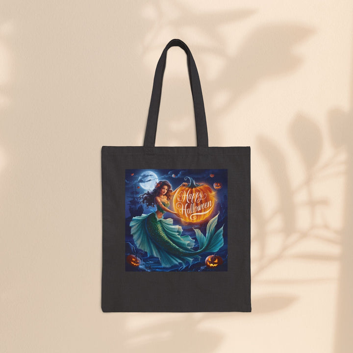 Sea Dragon Dreams black cotton canvas tote bag featuring a mermaid holding a glowing pumpkin for Halloween.