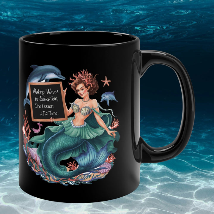 Sea Dragon Dreams black ceramic 11oz coffee mug featuring a mermaid illustration and Waves in Education quote.