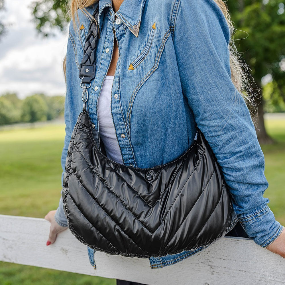 Sea Dragon Dreams black nylon half-moon HydroHobo crossbody bag with braided strap worn by a woman in denim