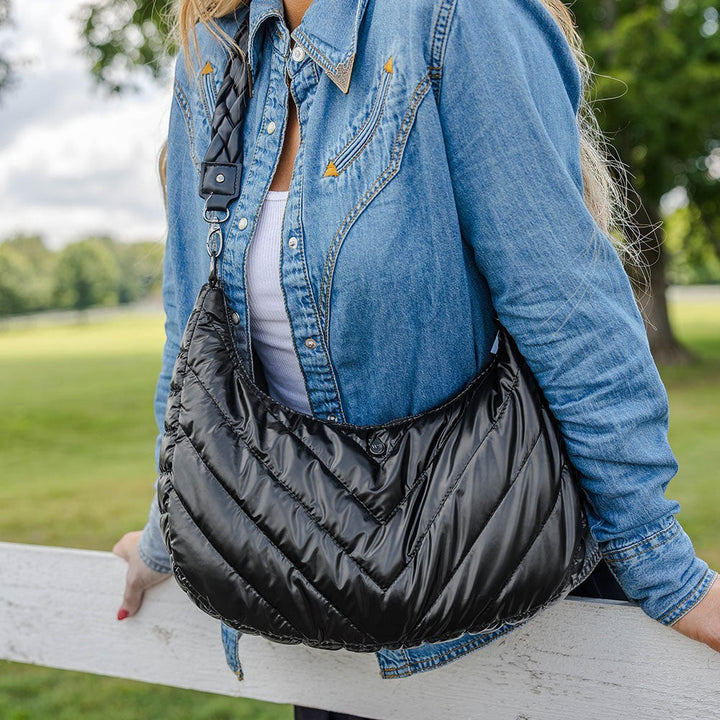 Sea Dragon Dreams black nylon half-moon HydroHobo crossbody bag with braided strap worn by a woman in denim