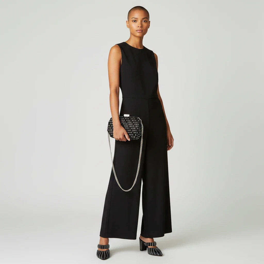 Model wearing a black jumpsuit with Sea Dragon Dreams black and white embellished heels and a matching clutch bag.
