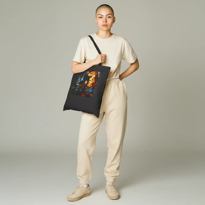 Model wearing a black Sea Dragon Dreams cotton canvas tote bag with a witchy Halloween graphic design