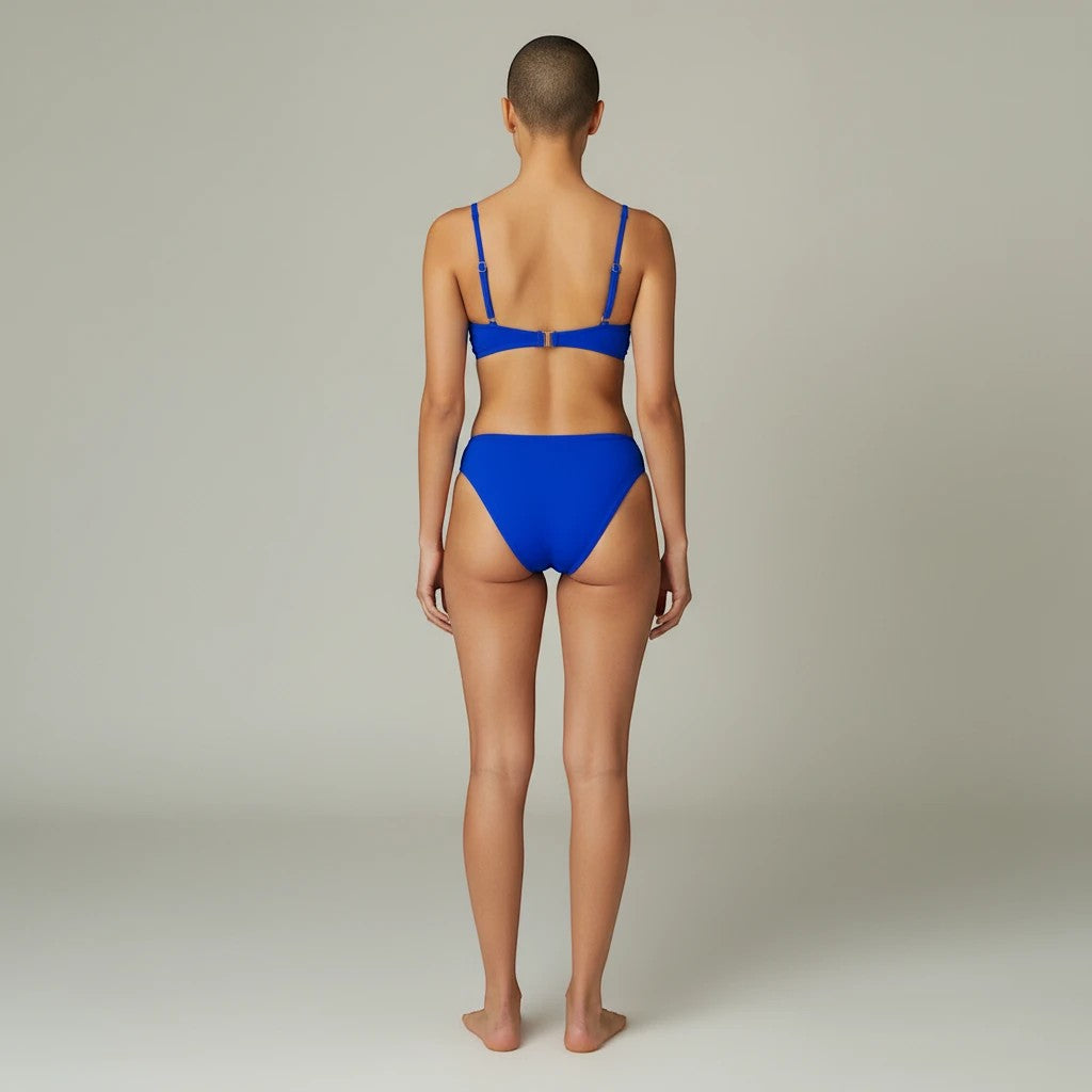 Back view of a model wearing a Sea Dragon Dreams solid blue push-up bikini set with a crop-style top.
