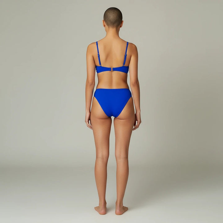 Back view of a model wearing a Sea Dragon Dreams solid blue push-up bikini set with a crop-style top.