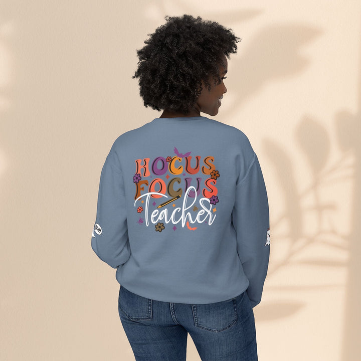 Sea Dragon Dreams unisex blue crewneck sweatshirt with Hocus Focus Teacher graphic on back, worn by a woman.