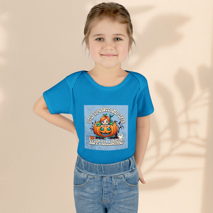 Sea Dragon Dreams infant bodysuit in blue with a Stay Spooky and Cute pumpkin graphic worn by a young child