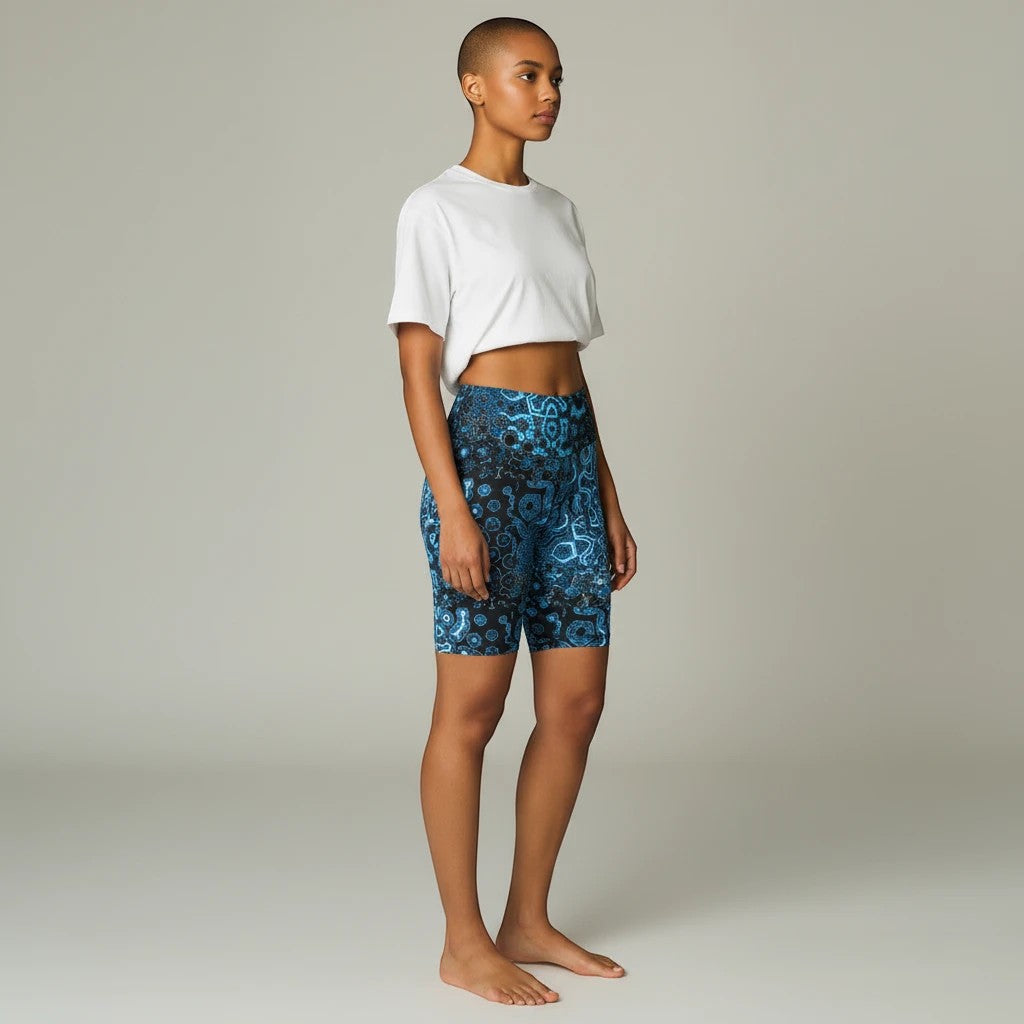 Model wearing Sea Dragon Dreams Shifting Blues workout shorts with a blue patterned print and a white crop top.
