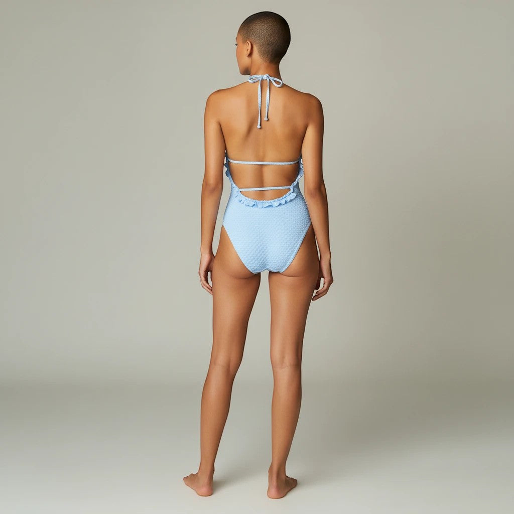 Sea Dragon Dreams light blue textured bikini with ruffle trim and lace-up back detail worn by a model, back view.