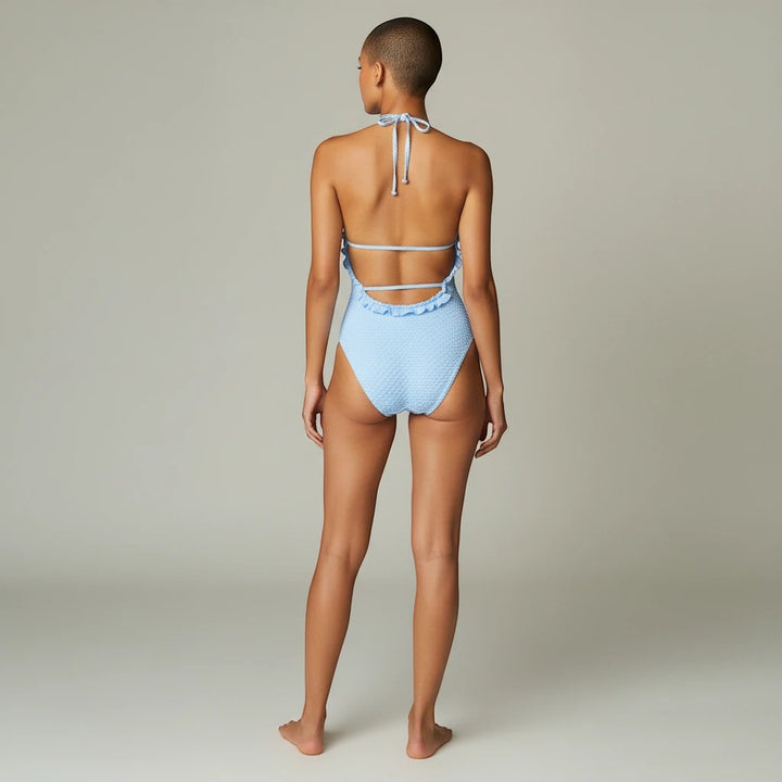 Sea Dragon Dreams light blue textured bikini with ruffle trim and lace-up back detail worn by a model, back view.