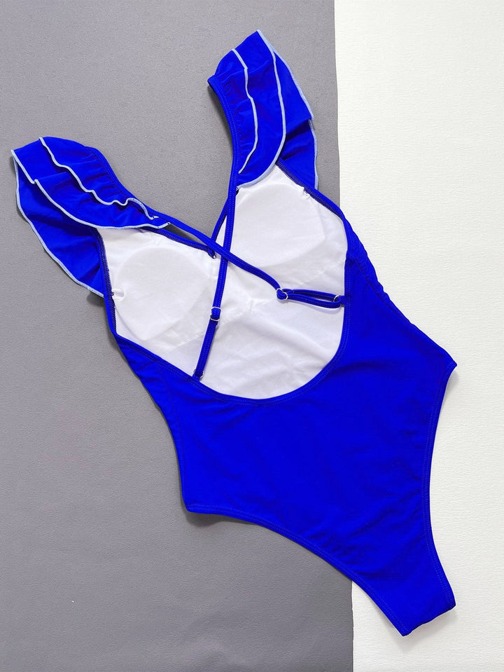 Sea Dragon Dreams royal blue one-piece swimsuit featuring ruffled shoulder straps and a crisscross backless design.