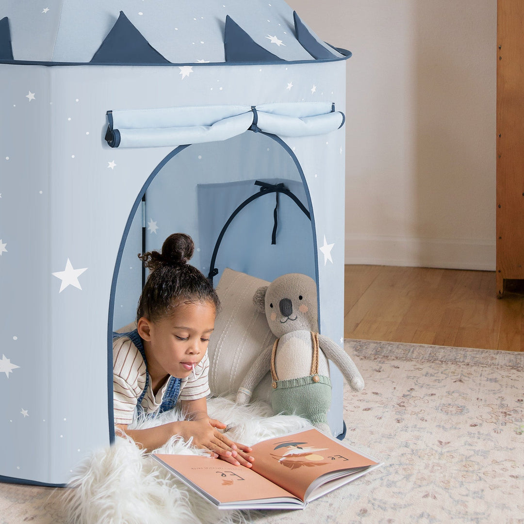 Sea Dragon Dreams 3-in-1 play tent in light blue with white stars, featuring a child reading inside on a soft rug.