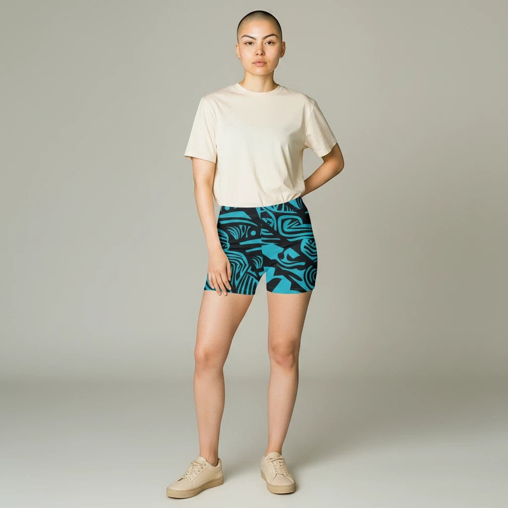 Sea Dragon Dreams women's skinny fit shorts in blue with a tribal pattern, worn by a model with a beige t-shirt.