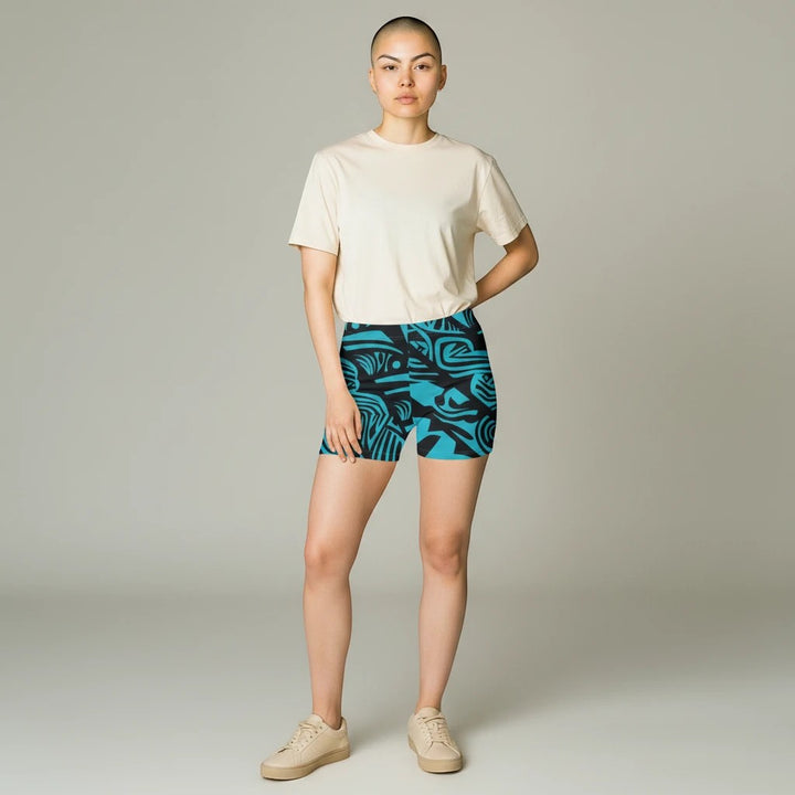 Sea Dragon Dreams women's skinny fit shorts in blue with a tribal pattern, worn by a model with a beige t-shirt.